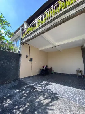 a person sitting on a motorcycle under a balcony at Villa Granatlia in Sanur