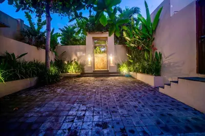 a front door of a house with a cobblestone driveway at Villa Kuda Sumba Umalas - Seminyak Area in Kerobokan
