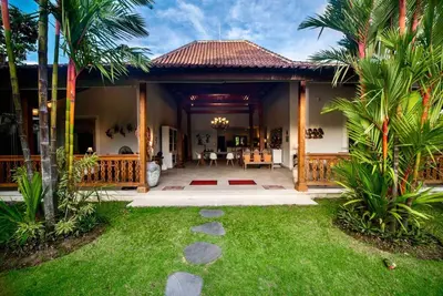 a house with a garden and a patio at Villa Kuda Sumba Umalas - Seminyak Area in Kerobokan
