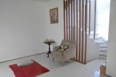 a living room with a chair and a red rug at Bracha house in Legian