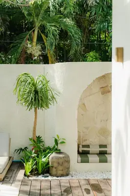 a palm tree in a pot next to a wall at LUX Casa Amore 4BR pick up from airport security PlayStation and Netflix in Seminyak