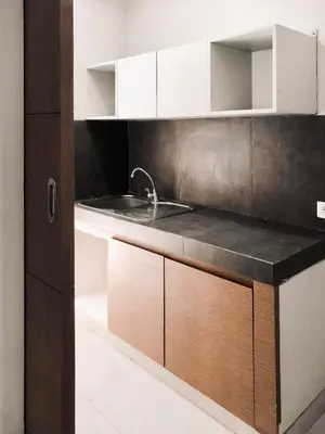 a kitchen with white cabinets and a sink at Nawasena Room Suite in Sanur