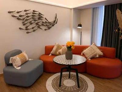 a living room with a couch and a table at Luminor Hotel Legian Seminyak - Bali in Legian