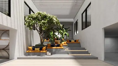a hallway with stairs with couches and a tree at voco Bali Seminyak by IHG in Seminyak