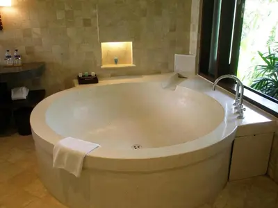 a large bath tub in a bathroom with a window at Barimantra 4BR Trees View Pool Villa CYN in Jimbaran