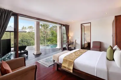 a bedroom with a large bed and a large window at Barimantra 4BR Trees View Pool Villa CYN in Jimbaran