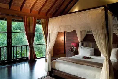 a bedroom with a bed and a large window at Sujiwana 2BR Luxury Jungle Pool View Villa CYN in Jimbaran