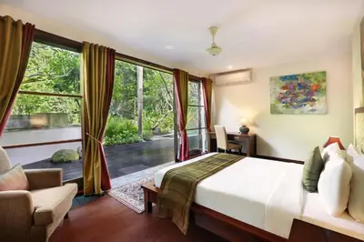 a bedroom with a bed and a large window at Sujiwana 2BR Luxury Jungle Pool View Villa CYN in Jimbaran