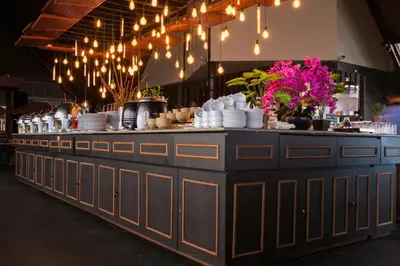 a buffet line with plates and dishes on it at Kutabex Beachfront Hotel in Kuta
