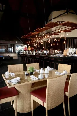 a dining room table with chairs and a counter at Kutabex Beachfront Hotel in Kuta