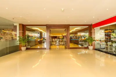a shopping mall with a lobby with potted plants at Kutabex Beachfront Hotel in Kuta