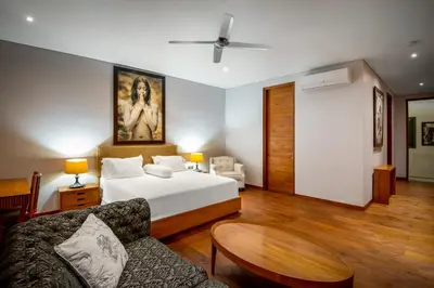 a bedroom with a bed and a table and a couch at Villa Eighty8 Private Residence with Gym & 20m Pool in Kerobokan