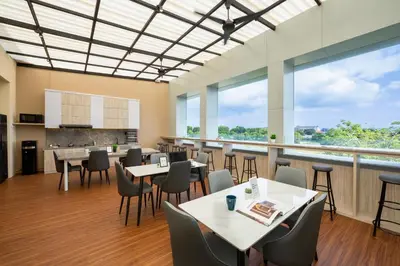 a restaurant with tables and chairs and large windows at Cove Tripuri House Bali in Denpasar