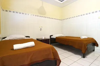 a room with two beds with towels on them at Gora Beach Inn in Kuta