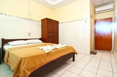 a bedroom with a bed with towels on it at Gora Beach Inn in Kuta