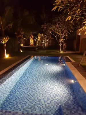 a swimming pool at night with lights at Villa Dharmatria in Nusa Dua