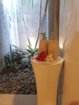 a vase with two candles and flowers on it at Villa Dharmatria in Nusa Dua