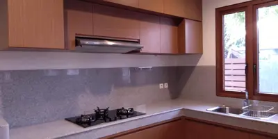 a kitchen with a stove and a sink at Villa Dharmatria in Nusa Dua