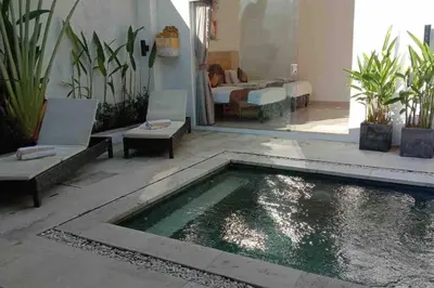 a pool in the middle of a room with chairs and a living room at UMARA villa bali x villa aydin kerobokan bali in Seminyak