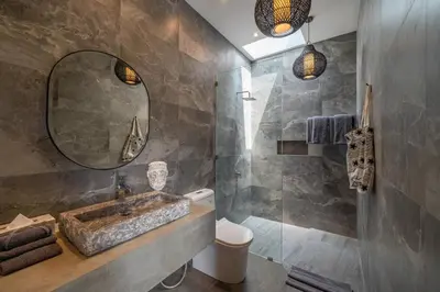 a bathroom with a sink and a mirror at Villa Koya : Luxurious and Modern 3BR Villa in Seminyak! in Seminyak