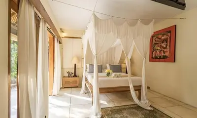 a bedroom with a bed with a canopy at Villa Umah Maya 3BR Seminyak in Seminyak