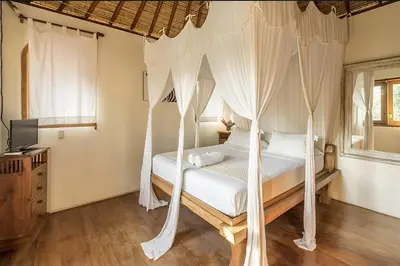 a bedroom with a bed with mosquito netting at Villa Umah Maya 3BR Seminyak in Seminyak