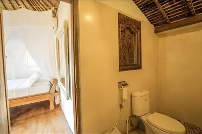 a bathroom with a toilet and a bed and a window at Villa Umah Maya 3BR Seminyak in Seminyak