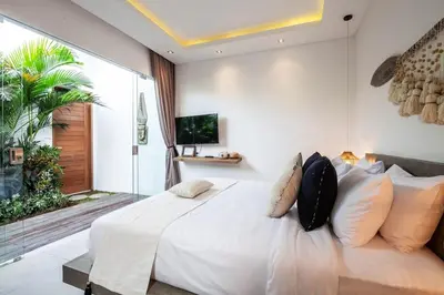 a bedroom with a large white bed with pillows at Spectacular 4BR Villa, 400m to Beachfront Bliss in Canggu