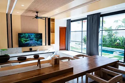 a living room with a dining table and a tv at La Boutique Lux's Villas Seminyak Bali in Seminyak