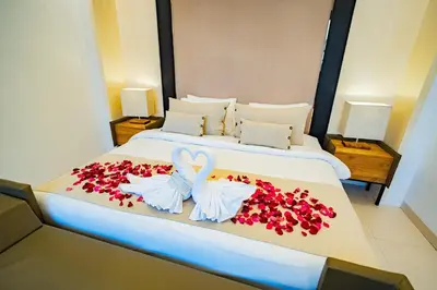 a bedroom with a bed with red flowers on it at La Boutique Lux's Villas Seminyak Bali in Seminyak