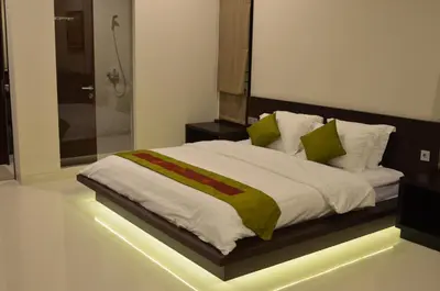 a bedroom with a large bed with a glass shower at The Arnaya in Kuta