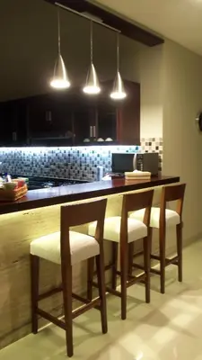 a kitchen with a table with chairs and lights at The Arnaya in Kuta