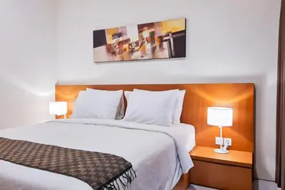 a hotel room with two beds and two lamps at Aldan Guest House Syariah in Pesanggaran