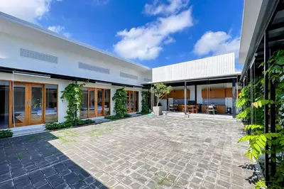 an empty courtyard of a white building with plants at Aldan Guest House Syariah in Pesanggaran