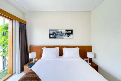 a bedroom with a large white bed and a window at Aldan Guest House Syariah in Pesanggaran