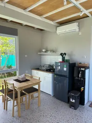 a kitchen with a table and a stove and a refrigerator at Monty’s Villa Umalas - 1 Bedroom in Kerobokan