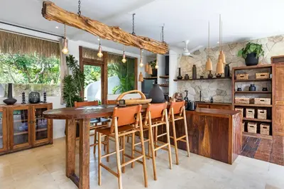 a kitchen with a wooden table and chairs at Villa Senya - Bali Bliss 3BR Mediterranean Escape with Private Pool, Stylish Retreat Between Seminyak & Canggu in Kerobokan