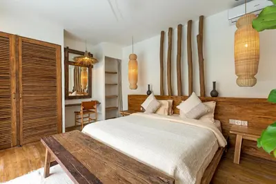 a bedroom with a large bed and a table at Villa Senya - Bali Bliss 3BR Mediterranean Escape with Private Pool, Stylish Retreat Between Seminyak & Canggu in Kerobokan