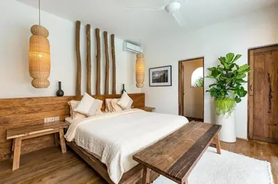 a bedroom with a bed and a wooden table at Villa Senya - Bali Bliss 3BR Mediterranean Escape with Private Pool, Stylish Retreat Between Seminyak & Canggu in Kerobokan
