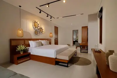 a bedroom with a large bed and a living room at Villa Ananya Seminyak by Nakula in Seminyak