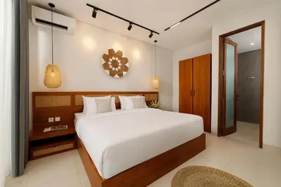 a bedroom with a large white bed and a mirror at Villa Ananya Seminyak by Nakula in Seminyak