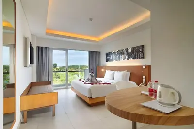 a hotel room with a bed and a table at Kuta Galleria Hotel in Kuta