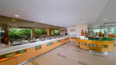 a restaurant with a counter with dishes on it at Kuta Galleria Hotel in Kuta