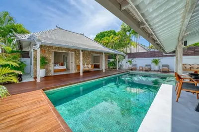 a swimming pool with a patio and a house at Beautiful villa Yang Tao in the heart of Seminyak with private staff in Seminyak