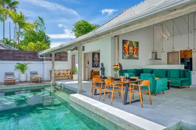 a patio with a table and chairs next to a pool at Beautiful villa Yang Tao in the heart of Seminyak with private staff in Seminyak