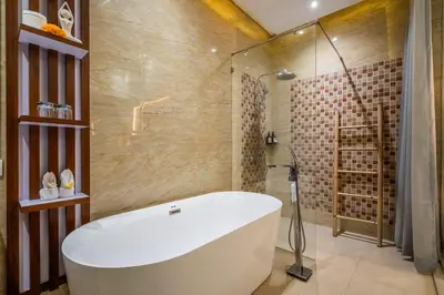 a bathroom with a white tub and a shower at Villa Amelie by JB Villas in Seminyak