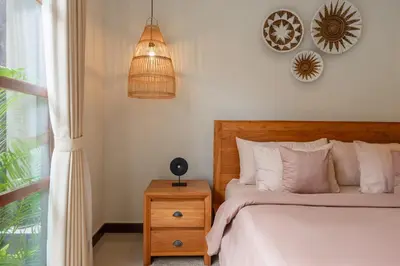 a bedroom with a bed and a pendant light at Villa Nana by Pertama Management in Seminyak