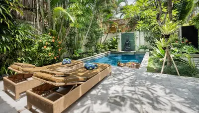 a swimming pool in a backyard with wicker furniture at Villa Seriska Seminyak, 5-Star Private Pool Villa, Walk to Dining & Shopping in Seminyak