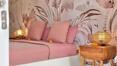 a pink bed with two pillows and a table at Villa Anouk in Seminyak