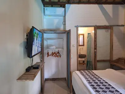 a bedroom with a bed and a television in a room at Oma Joglo Jimbaran in Jimbaran